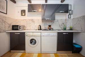 a kitchen with a washing machine and a microwave at Apartman Park 2 in Slavonski Brod