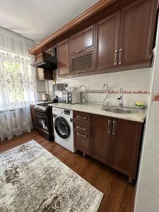 a kitchen with a sink and a washing machine at AzNiLux Boulevard in Muruntau