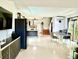 パタヤ・サウスにあるWarisa Happy Pool Villa Near Pattaya Beachのテーブルと椅子のあるキッチンとリビングルーム