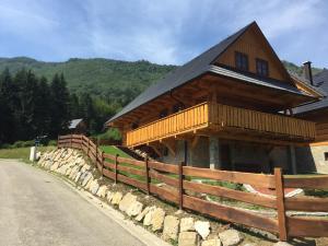 eine große Holzhütte mit einem Zaun an einer Straße in der Unterkunft Drevenica Vanesa in Terchová