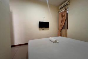 a bedroom with a bed and a tv on the wall at OYO 94785 Diana Homestay Syariah in Sunggal +19 photos