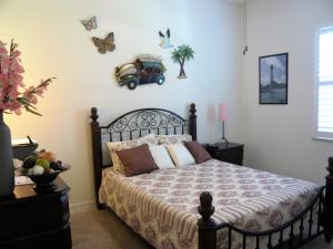 1 dormitorio con 1 cama con marco negro y mariposas en la pared en Villa Cape Florida, en Cabo Coral