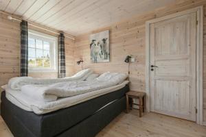 a bed in a room with wooden walls at Modern Family Cabin Near Vinterland Ski Resort in Lifjell