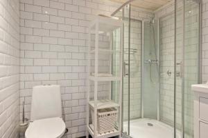 a white bathroom with a shower and a toilet at Modern Family Cabin Near Vinterland Ski Resort in Lifjell +27 photos