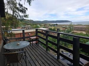 a balcony with a table and chairs and a view of the ocean at Cabañas by Puertecillo in Puertecillo