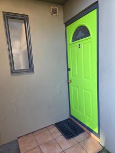 una puerta verde en el costado de un edificio en 3-Bedrooms Home near CBD, en Christchurch