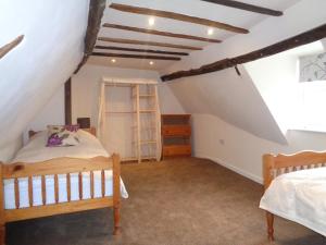 1 Schlafzimmer mit 2 Betten im Dachgeschoss in der Unterkunft Minsmere Cottage in Yoxford