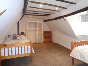 YoxfordにあるMinsmere Cottageのベッドルーム(ベッド2台付)が備わる屋根裏部屋です。