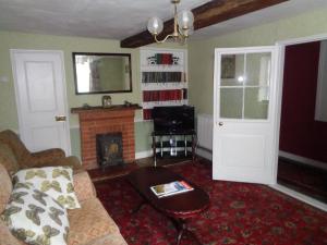a living room with a couch and a fireplace at Minsmere Cottage in Yoxford