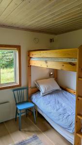 a bedroom with a bunk bed and a blue chair at Charming Cottage Near Sea On Fårö in Fårö