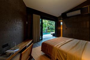 a bedroom with a large bed and a wooden desk at Villa Suki in Canggu