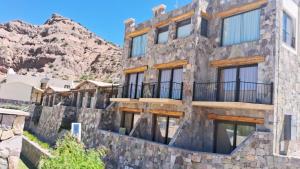 an old stone building with a mountain in the background at canto del viento in Tilcara