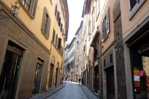 an empty street in an alley between buildings at Hotel Renaissance in Florence