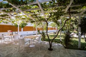 a patio with tables and chairs under a pergola at Jaz Garden Residence in Budva