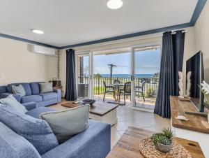a living room with a blue couch and a view of the ocean at Cabarita Beachfront Ocean View 12 in Cabarita Beach