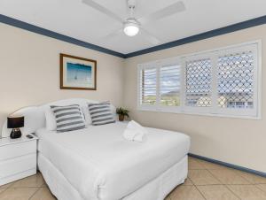 a bedroom with a white bed and a window at Cabarita Beachfront Ocean View 12 in Cabarita Beach +18 photos