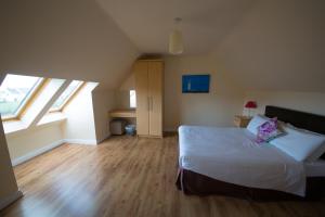 ein Schlafzimmer mit einem Bett und zwei Fenstern in der Unterkunft Doolin Village Lodges in Doolin