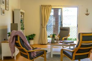 a living room with two chairs and a table at The Lazy Pelican in Tin Can Bay +14 photos