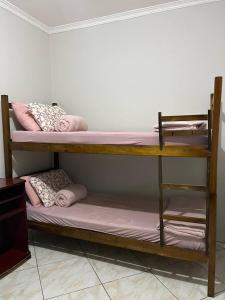 two bunk beds in a room with pink sheets and pillows at Hostel Pedacinho do Céu in Barueri