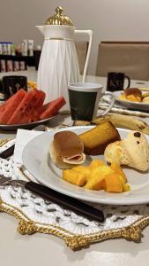 a plate of food with a sandwich on a table at Hostel Pedacinho do Céu in Barueri
