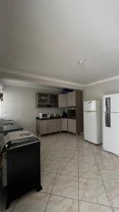 a large kitchen with a white refrigerator and cabinets at Hostel Pedacinho do Céu in Barueri +33 photos