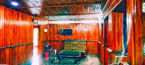 a room with a couch in a wooden wall at Banasura Green paradise , Villa , Deluxe rooms , Budget rooms in Padinjarathara