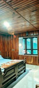 a bedroom with a bed in a room with wooden walls at Banasura Green paradise , Villa , Deluxe rooms , Budget rooms in Padinjarathara