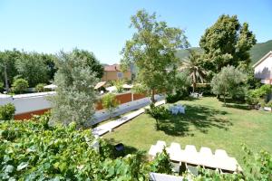 布德瓦的住宿－Jaz Garden Residence，享有带白色椅子和树木的花园美景