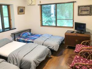 霧島市にあるGlamping Himeshara - Vacation STAY 01948vのベッド2台、机、テレビのある部屋