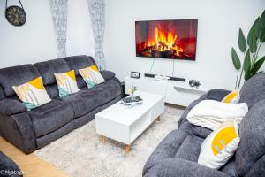 a living room with two couches and a fireplace at Dee apartments in Kisii