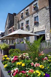 an umbrella and flowers in front of a building at Hôtel Le Roosevelt in Givet