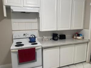 a kitchen with a white stove and white cabinets at Central Vally Private House in Abbotsford