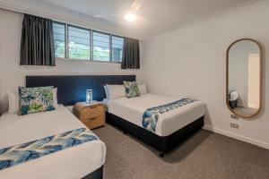 Habitación pequeña con 2 camas y espejo. en Frangipani 107 by HamoRent on Hamilton Island, en Hamilton Island 18 fotos más