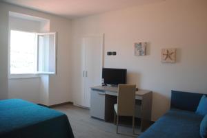 a room with a desk with a computer and a bed at Affittacamere Piazza Castello in Manarola +26 photos