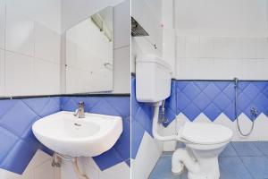 a bathroom with a sink and a toilet and a mirror at Super Collection O Market Road Ernakulam in Cochin