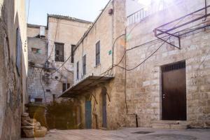 eine Gasse in einem alten Steingebäude mit einer Tür in der Unterkunft Mark House in Nazareth