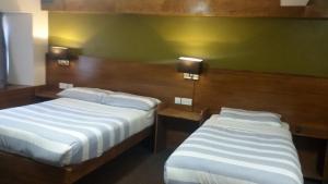 2 camas en una habitación de hotel con paredes verdes en Adelphi Hotel, en Edimburgo
