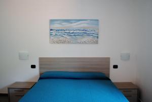 a bedroom with a bed with a painting on the wall at Affittacamere Piazza Castello in Manarola