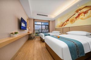 une chambre d'hôtel avec deux lits et une fenêtre dans l'établissement Vienna Hotel Nanning Xiangsi Lake University Town, à Nanning