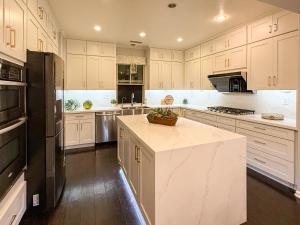 a kitchen with white cabinets and a black refrigerator at #Marbella Lane - Vibrant 4BR Home in Irvine in Irvine