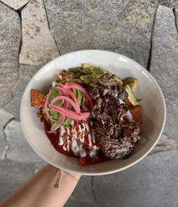 a white bowl of food with meat and vegetables at Suites Lassa in Ensenada +24 photos