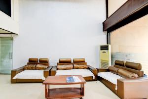 a room with two beds and a coffee table at Super Townhouse Narayanaguda Metro Station Formerly Hotel Anshu Grand in Vidya Nagar