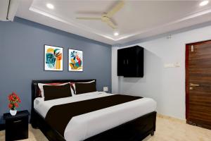 a bedroom with a large bed with blue walls at Super Collection O Dr. NTR University Of Health Sciences Formerly Hotel V Elite in Vijayawāda +21 photos