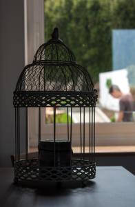 a black bird cage sitting on top of a table at Casa do Simão in Nordeste