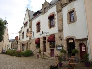an old building with an orange sign on a street at Hôtel Les Deux Magots in La Roche-Bernard