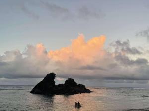 a couple of people in a boat in the ocean at Beach Front Cabana 1, Puraran Surf Resort in Sampong