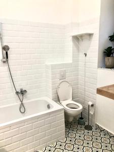 a bathroom with a white tub and a toilet at Muzeum design Apartment at downtown in Budapest