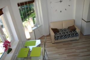 a living room with a couch and a glass table at Apartament Light & Bright in Międzyzdroje