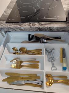 un cassetto pieno di utensili d'oro su un bancone di Senamiesčio apartamentai a Klaipėda