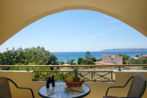 a table on a balcony with a view of the ocean at Manos in Megás Limniónas